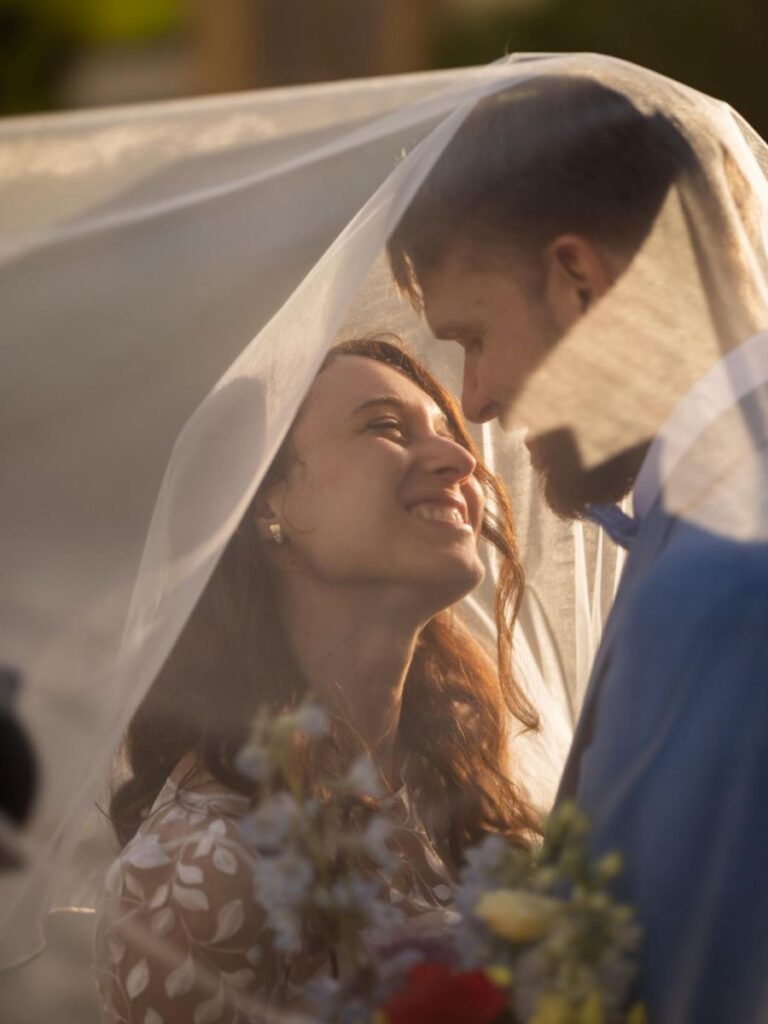 sposa felice sotto il velo durante matrimonio all’aperto a Mantova