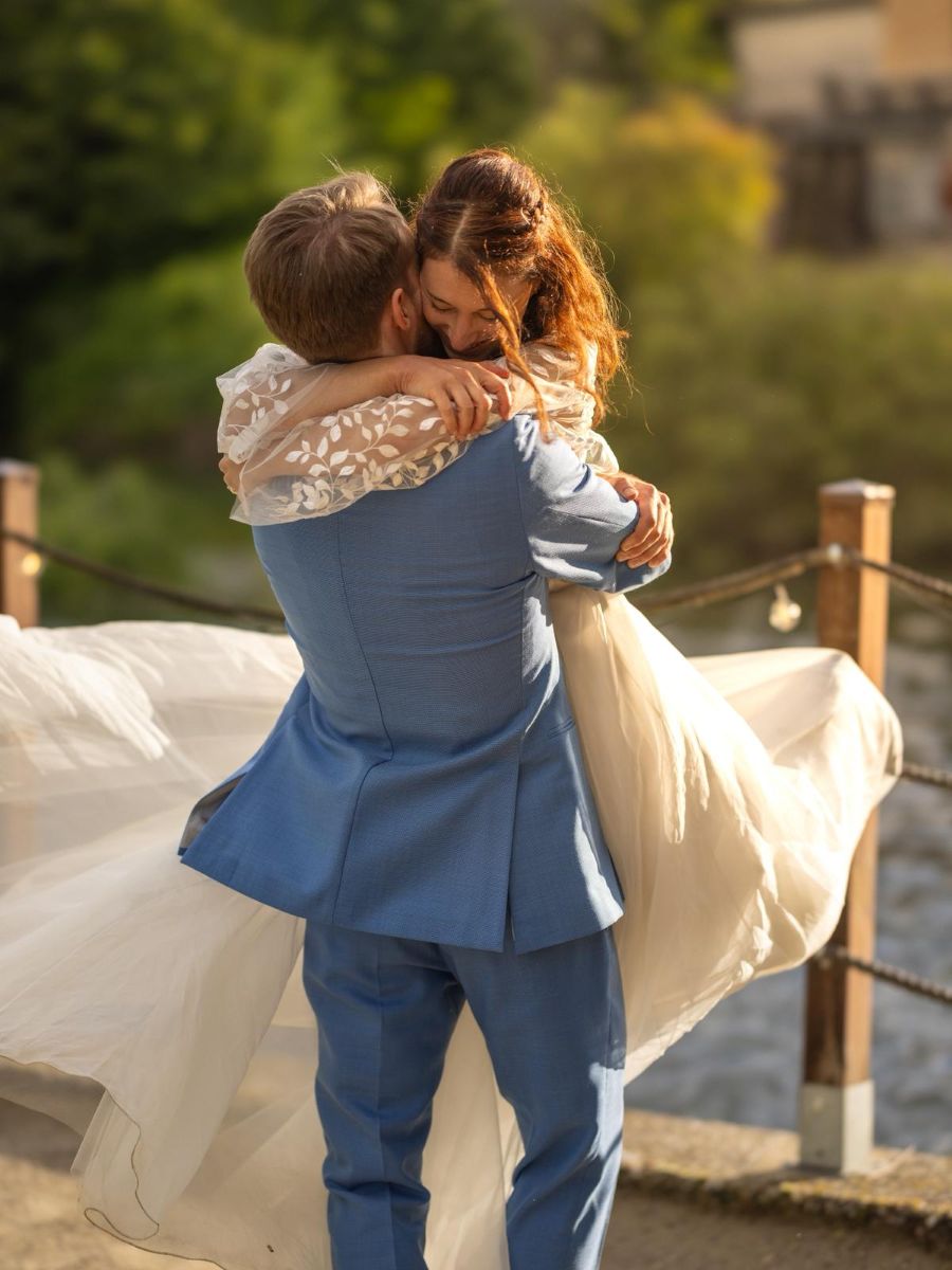 sposi abbracciati dopo il temporale durante matrimonio sul fiume