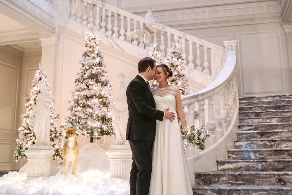 Sposa incinta con abito da sposa stile impero durante un matrimonio invernale.