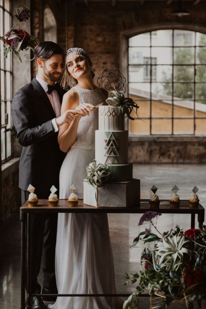 Taglio della torta con abito da sposa ricamato e copricapo gioiello