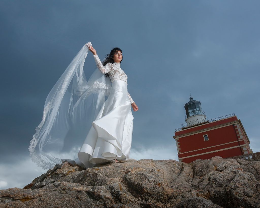 Sposa con velo lungo mosso dal vento durante un matrimonio in Sardegna