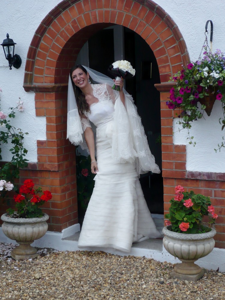 Sposa che porta il velo raccolto sul braccio dopo la cerimonia